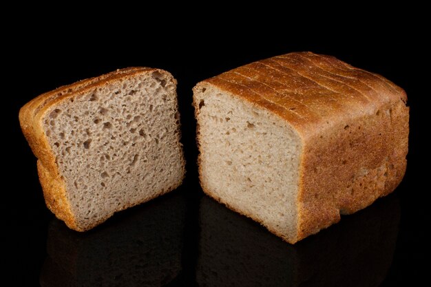 Ordinary bread cut into pieces on a black background