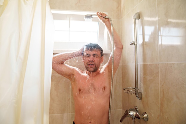 An ordinary man takes a shower in a small bathroom