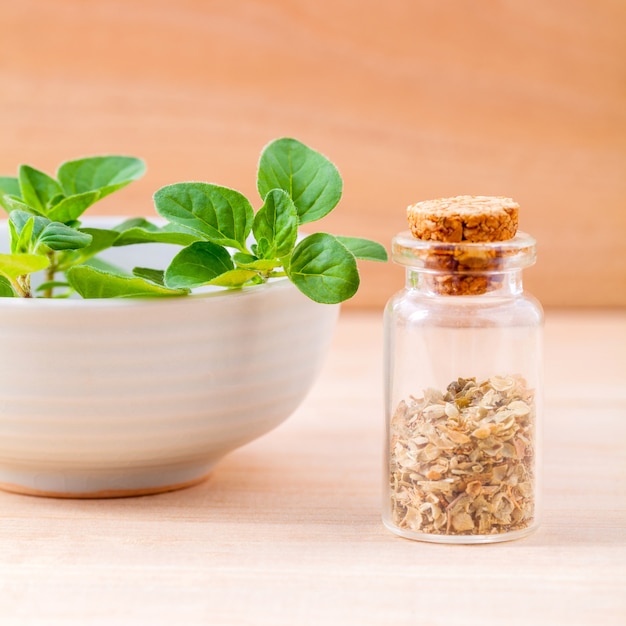 Oregano in de fles op houten achtergrond.