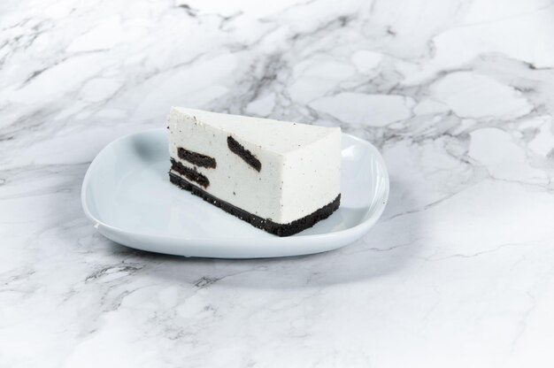 Oreo cheesecake slice served in a basket side view on dark background