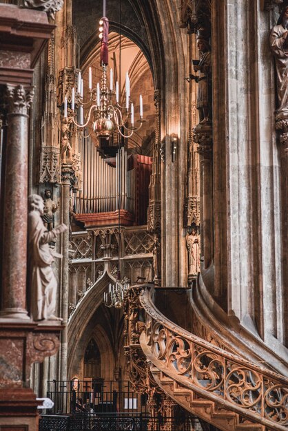 a organ in a cathedral with a chandelier hanging from the ceiling