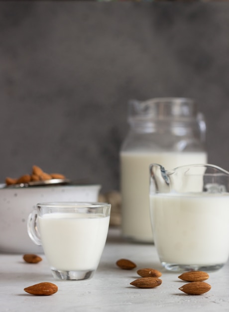 Organic almond milk in glass jugs with ingredients