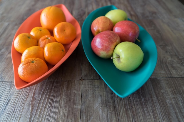 Органические яблоки, апельсины и мандарины в лотках