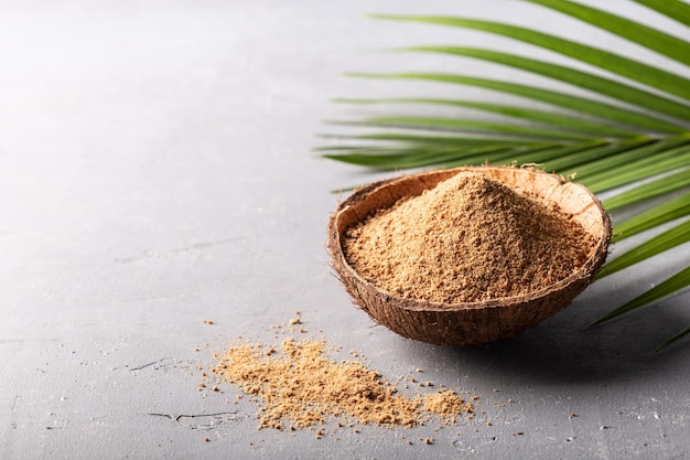 Photo organic brown palm or coconut sugar on grey background