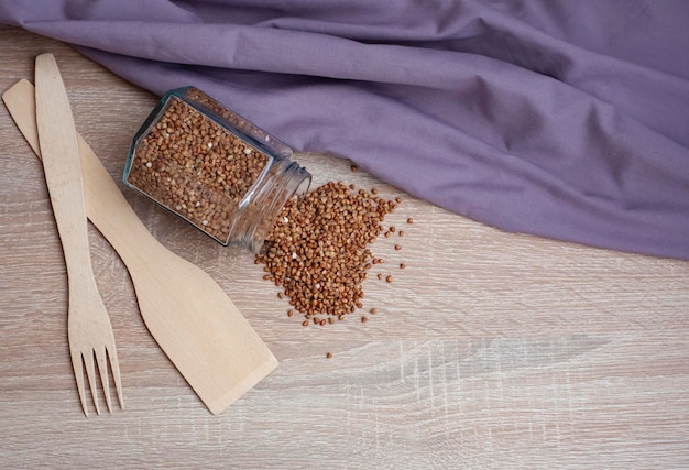 Organic buckwheat groats in a wooden bowl with a spoon on a linen napkin on a wooden table Banner Rustic style Healthy nutrition concept Buckwheat contains a large amount of vitamins and minerals