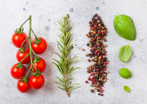 Organic cherry sugardrop tomatoes on the vine with basil and pepper