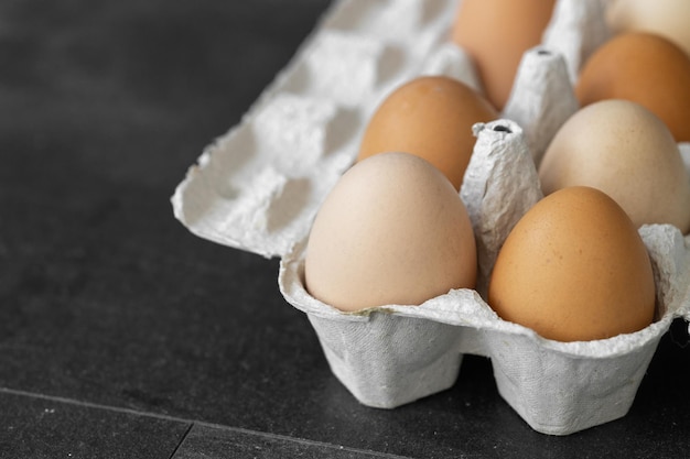 Organic chicken eggs on dark wooden background with copy space