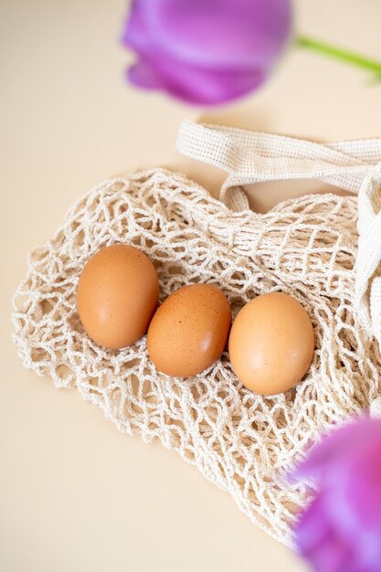 organic chicken eggs lie on a string bag