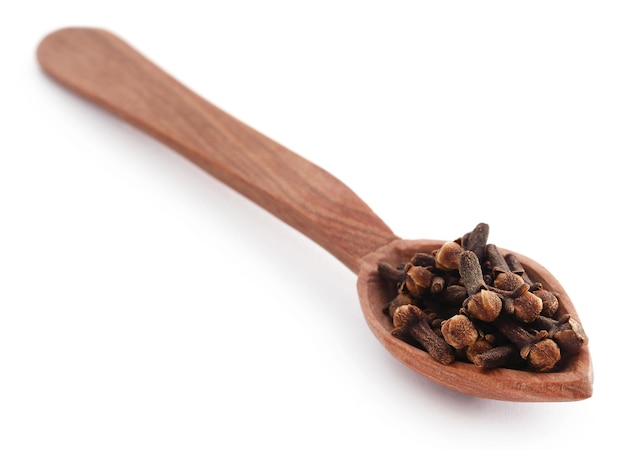 Organic clove in wooden scoop isolated over white background