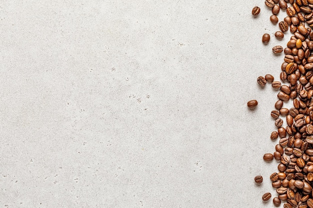 Organic coffee beans border over light stone background copy\
space for text