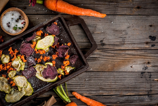 Organic diet food. The vegan diet. Dried vegetables. Homemade chips from beets, carrots and zucchini. On old wooden rustic table, with fresh vegetables. copyspace top view