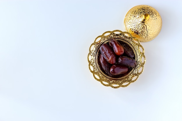 Organic dried dates in traditional arabic golden plate. Holy month Ramadan concept. Top view.