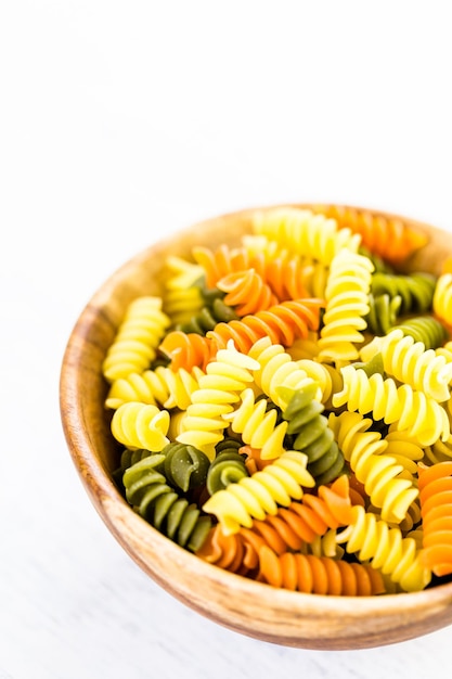 Organic dry pasta in small round bowl.