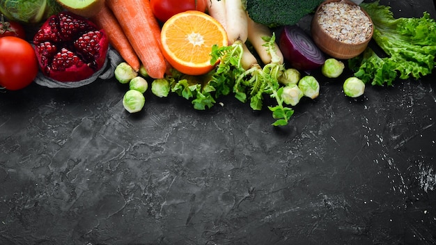 Organic food on a black stone background Vegetables and fruits Top view Free copy space