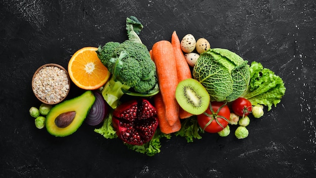 Organic food on a black stone background Vegetables and fruits Top view Free copy space