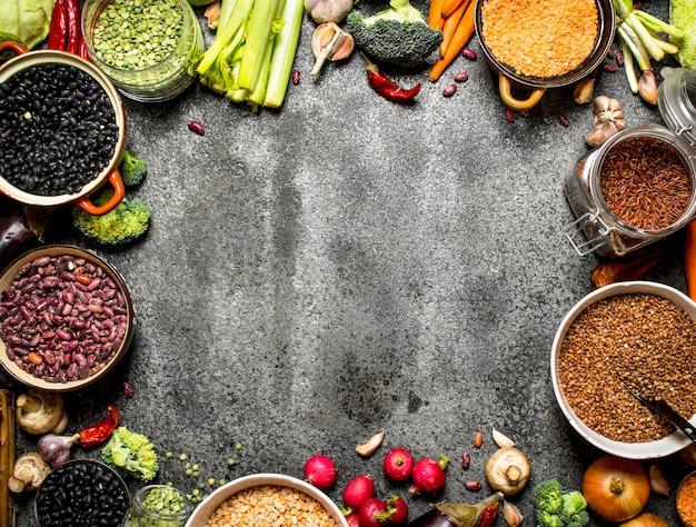 Organic Food. Frame of fresh vegetables and legumes. On rustic background.