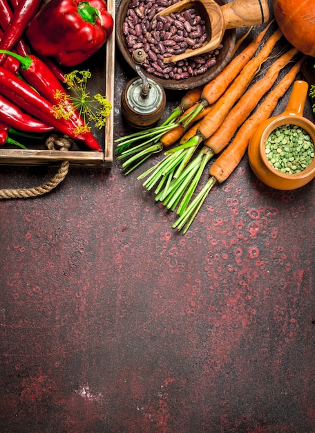 Cibo organico. raccolto fresco di legumi e ortaggi. su fondo rustico.