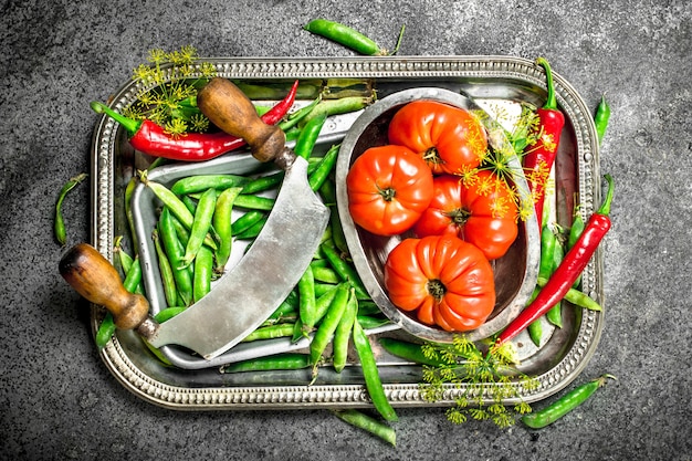 사진 유기농 식품. 녹색 완두콩, 토마토, 핫 칠리 페 퍼는 시골 풍 테이블에 강철 쟁반에.