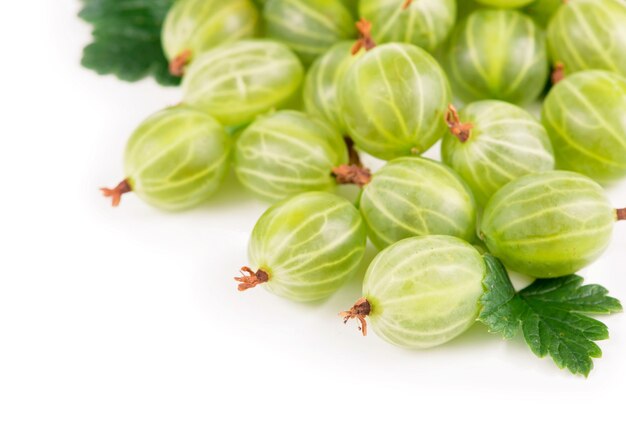 Органические продукты питания, здоровое питание, зеленые плоды крыжовника с листьями на белом