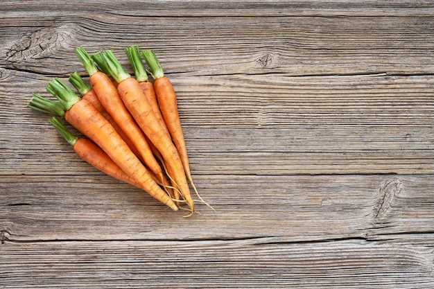 Organic food. Red carrots in the on old wooden background. 