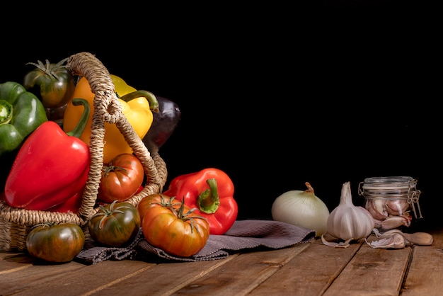 Organic food vegetables in wicker basket on rustic wooden table.