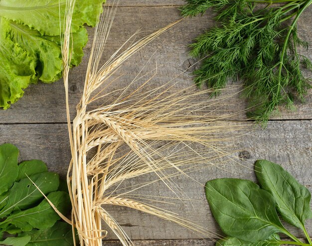 Organic foodwheat spica and ingredients for salad on old rustic wooden table top view