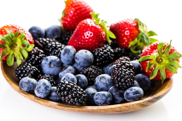 Organic fresh mixed fruit in wood bowl on the table.