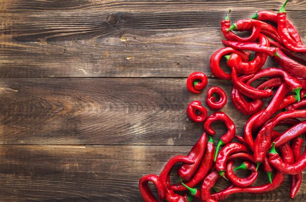 Organic fresh red hot chili peppers on rustic wooden background. Top view.