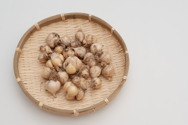 Organic garlic (Allium sativum) in woven bamboo basket.