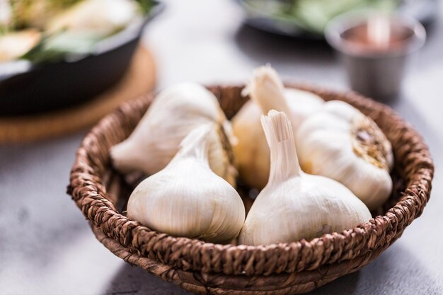 Organic garlic cloves in small wicker basket.