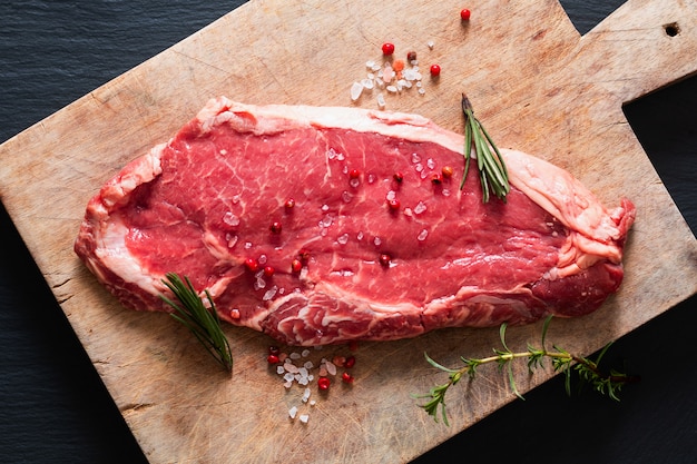 Bistecca di manzo filetto di carne cruda di alimentazione di vetro organico sul tavolo di pietra ardesia nera