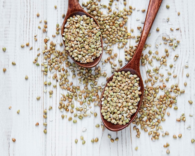 Grano saraceno verde biologico su un tavolo di legno bianco