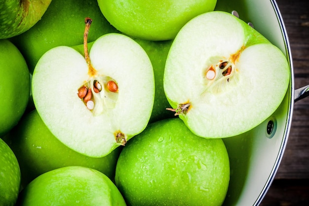 Organic green juicy apples in colander closeup