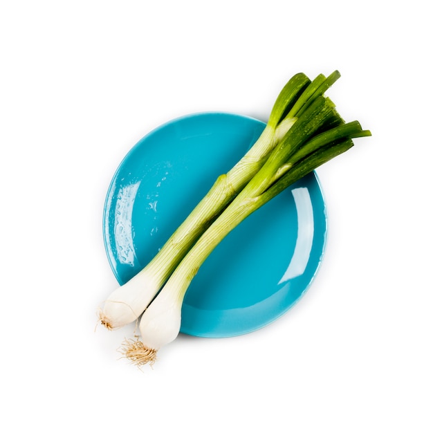 Organic green onion on blue plate 