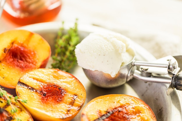 Photo organic grilled peaches with scoop of vanilla ice cream.