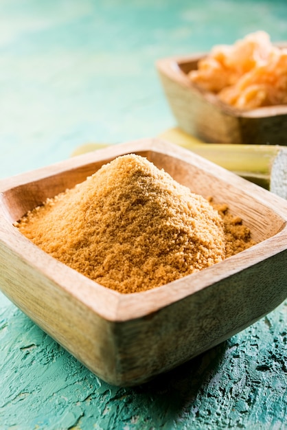 Organic Gur or Jaggery Powder is unrefined sugar obtained from concentrated sugarcane juice. served in a bowl. selective focus