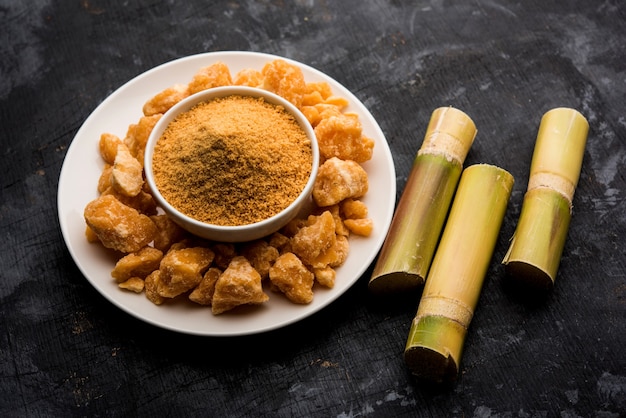 Foto organic gur o jaggery powder è zucchero non raffinato ottenuto dal succo concentrato di canna da zucchero. servito in una ciotola. messa a fuoco selettiva