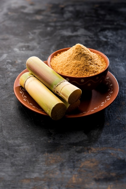 Organic Gur or Jaggery Powder is unrefined sugar obtained from concentrated sugarcane juice. served in a bowl. selective focus