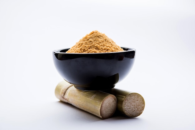 Organic Gur or Jaggery Powder is unrefined sugar obtained from concentrated sugarcane juice. served in a bowl. selective focus