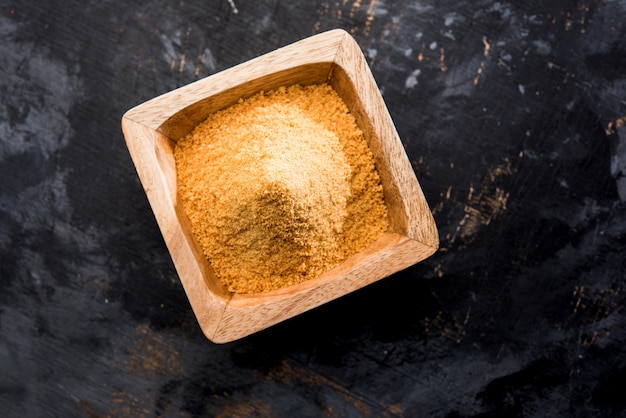 Organic Gur of Jaggery Powder is ongeraffineerde suiker die wordt verkregen uit geconcentreerd suikerrietsap. geserveerd in een kom. selectieve focus