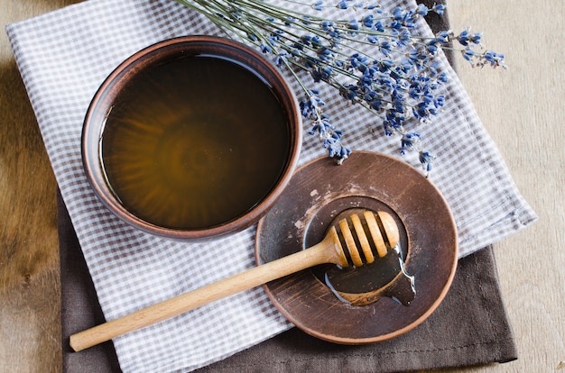 Organic honey and lavender flowers on wooden table.