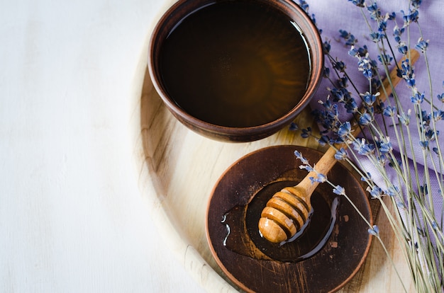 Organic honey and lavender flowers on wooden table.