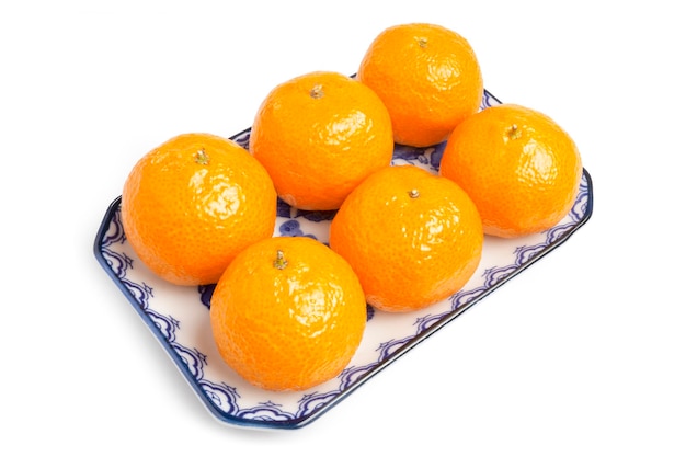 유기농 Jeruk Baby Santang 또는 만다린 베이비 오렌지는 흰색으로 격리된 파란색 접시에 제공됩니다.