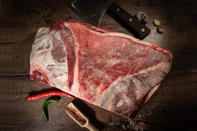 Organic machete or hanger butcher steak near butcher knife with pink pepper and rosemary Black background Top view side view