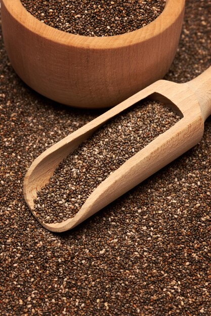 Organic natural chia seeds wooden scoop and bowl closeup