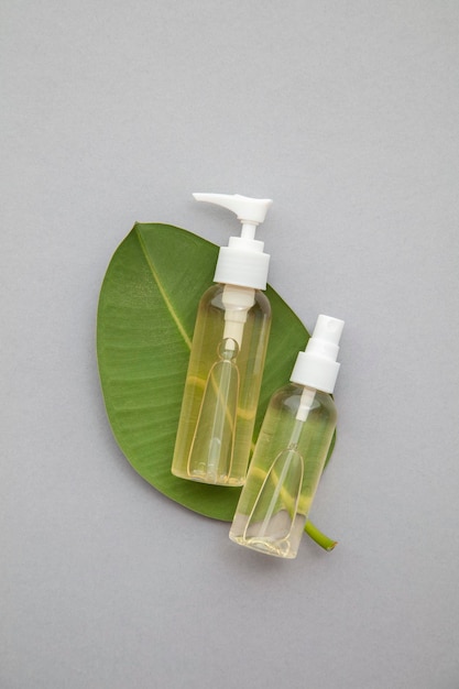 Organic natural cosmetic product with a green leaf on a grey background