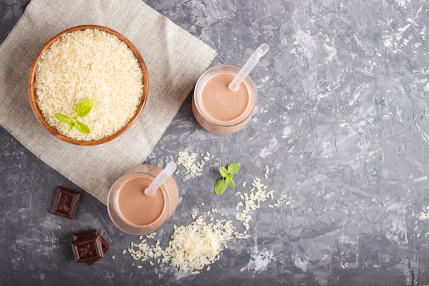 Organic non dairy rice chocolate milk in glass and wooden plate