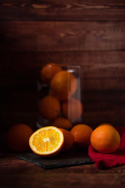 Organic oranges in glass jar on wooden table