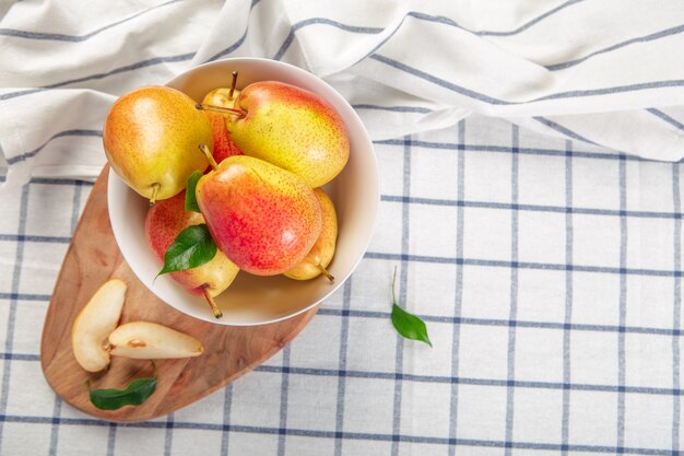 Organic pears laying down on a lightly dotted kitchen cloth