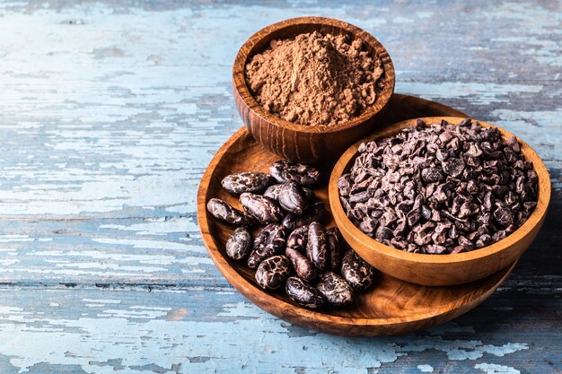 Organic raw cocoa beans, nibs in wooden bowls